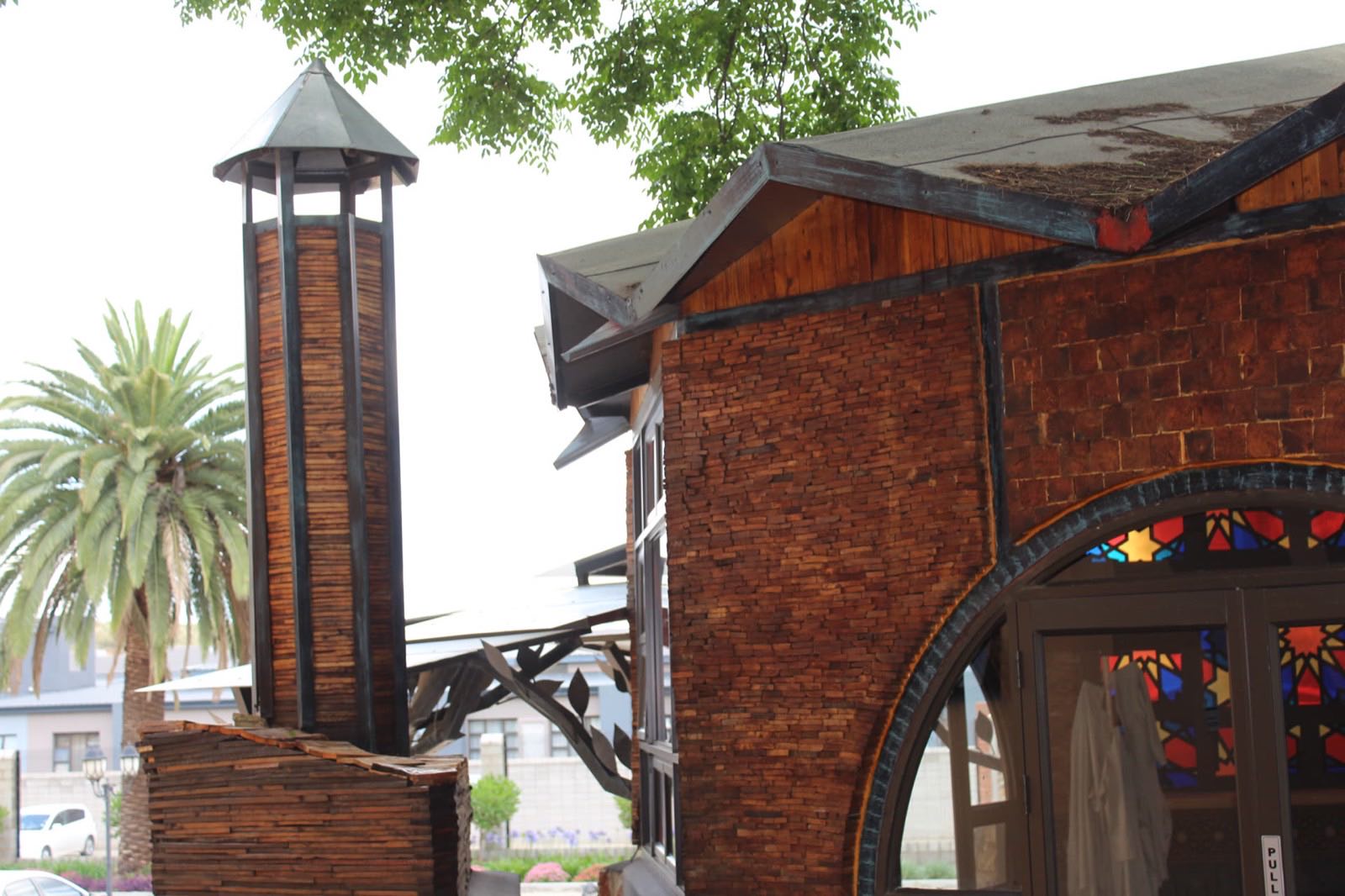 The musallah at Qurtuba Precinct, with its pallet-timber tower and stained-glass arch